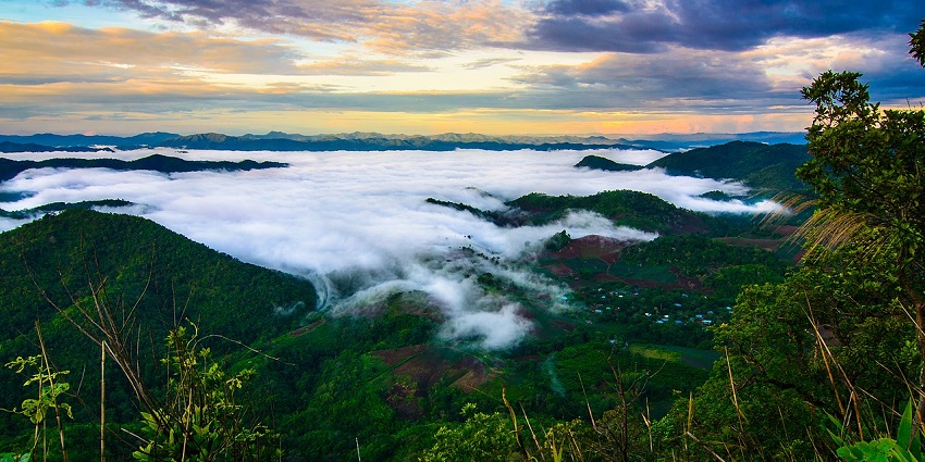 Vibrant sunrise over misty mountains and valleys covered with clouds in Vietnam.
