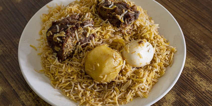 A large platter filled with a generous serving of savoury, egg, and aromatic mutton biryani.
