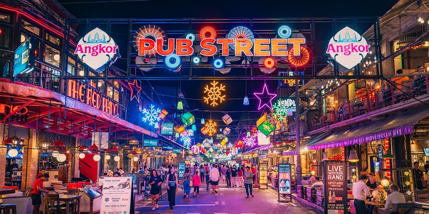 Entrance of Pub Street Night Market is bustling with shoppers in vibrant Cambodia.
