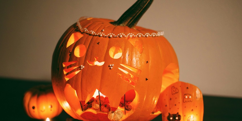 Carved pumpkins in the shape of spooky figures are illuminated during Halloween, similar to what's expected in Halloween day 2025.