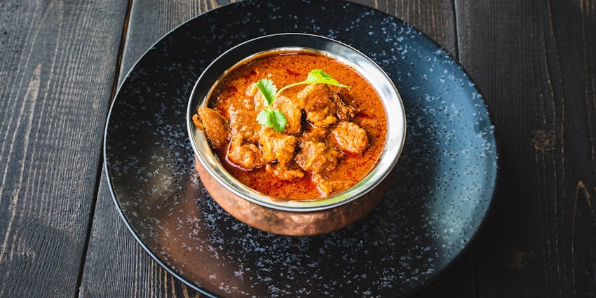 A plate of creamy butter chicken served at Recipes Restaurant with rich spices.