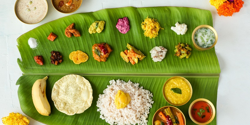 The Onam Sadya is served on a piece of banana leaf with rice, banana, and other delicacies.
