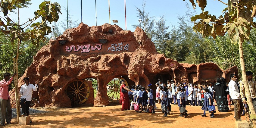 Entrance of Rock Garden Hubballi with stone structures and visitors, showcasing popular parks in Karnataka.
