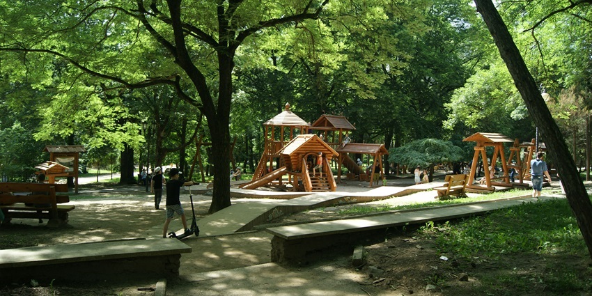 Wooden slides and children’s play area set in a green, family-friendly city park.