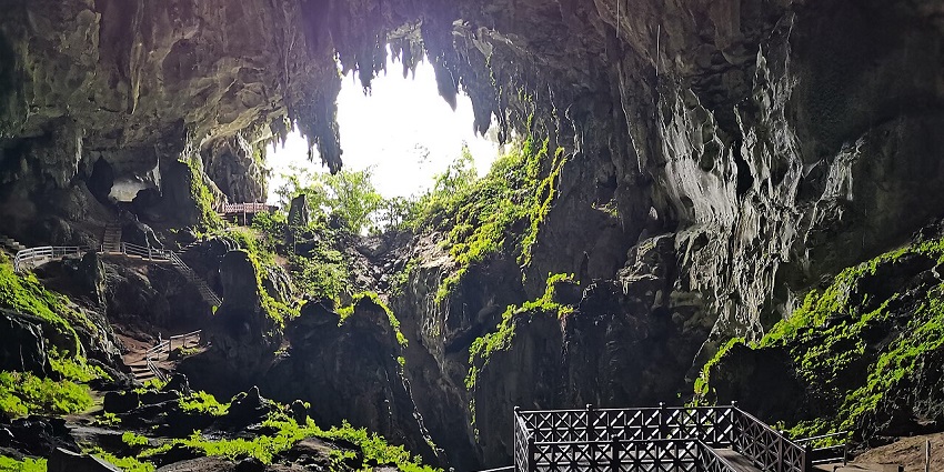 Massive underground cavern with rugged rock walls and minimal lighting inside the Sarawak Chamber.
