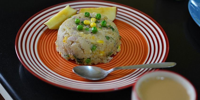 Upma, a popular South Indian breakfast, is served with a topping of peas and corn.
