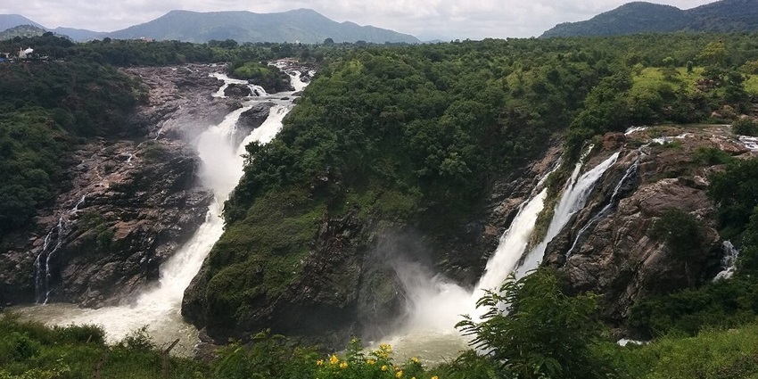A panoramic view of twin waterfalls in a lush valley, perfect for picnic places in Karnataka.