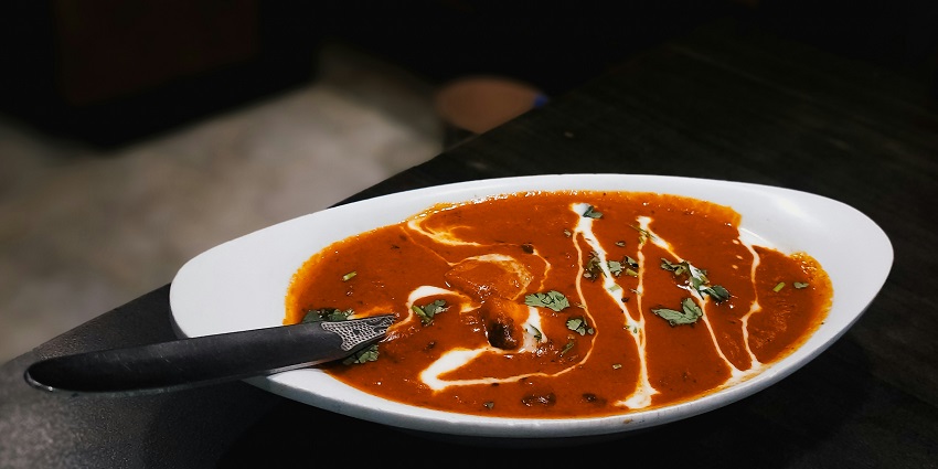 Indian curry served in a bowl at Shree Sanskar Pure Veg Restaurant on a dining table.