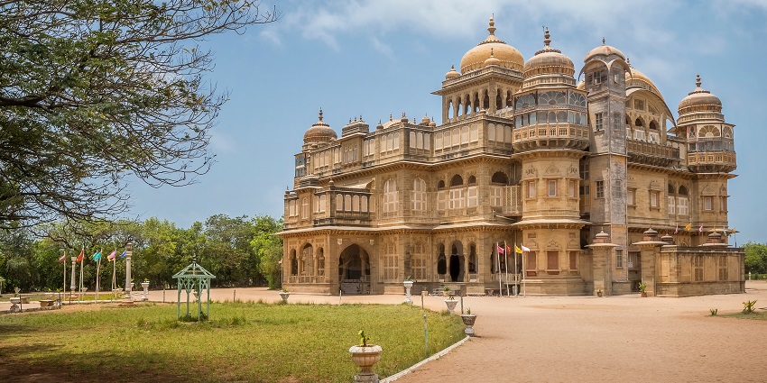 Vijay Vilas Palace, a historic seaside palace surrounded by gardens and trees.