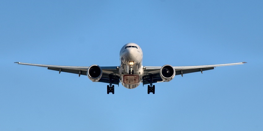 An airplane flying mid-air at Silchar Airport, showcasing connectivity via airports in North East India.