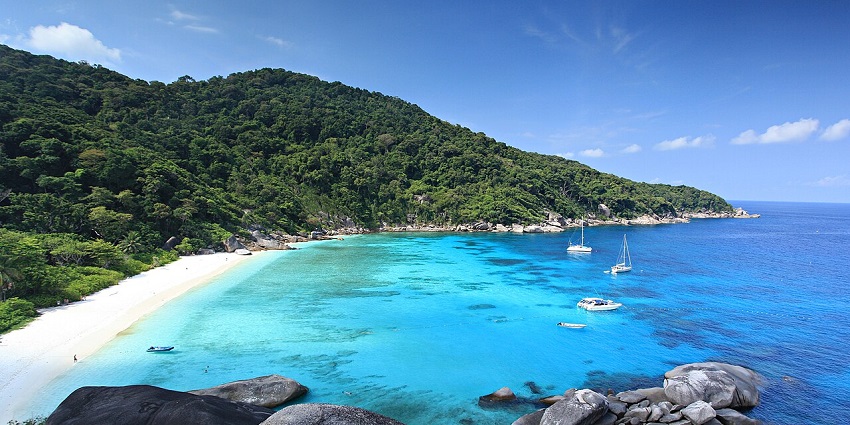 White sandy beach, turquoise waters, and yachts at Mu Ko Similan, national parks in Thailand.
