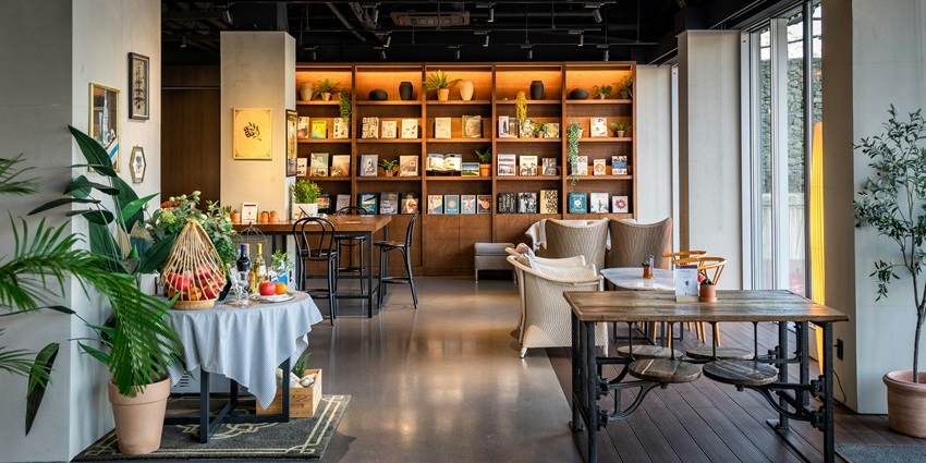 Interior view of the Simple Life Restaurant with a wooden table and chairs, and a bookshelf, one of the top veg restaurants in Malaysia.
