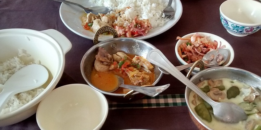 Ema Datshi appears as a rich dish, with visible pieces of green chillies and cheesy sauce, one of the Indian restaurants in Bhutan.
