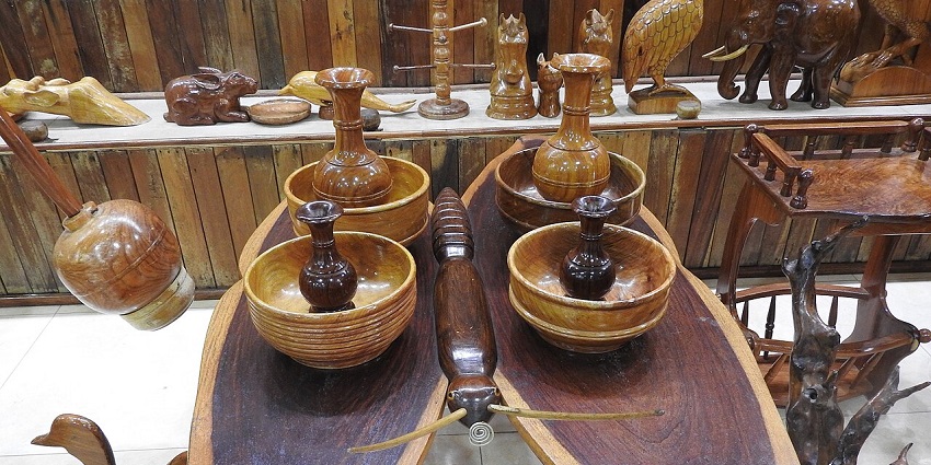 A display of various wooden handicrafts and artefacts, including a large wooden sculpture of a head.