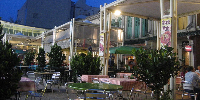 Outdoor dining area with checkered tablecloths at Snack World in evening light, one of the best restaurants in Singapore.
