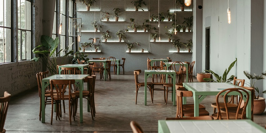 Spring Court Restaurant interior featuring tables, chairs, and wall plants, one of the restaurants in Chinatown.
