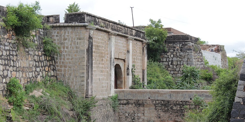 The stone gateway of Srirangapatna Fort is surrounded by high walls and greenery around it, one of the popular forts in Karnataka.
