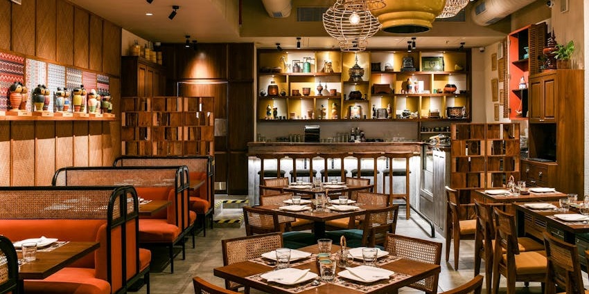 Stylish restaurant with warm lighting, wooden décor, booth seating, and wall displays.