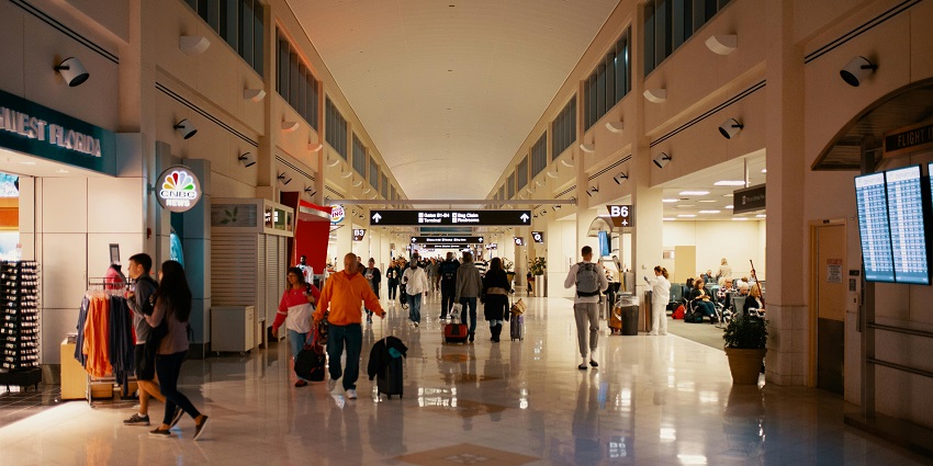 Passengers walking through the terminal with signage and luggage at airports in Bali.
