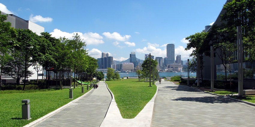 Open lawn and harbour view with walkways at Tamar Park, one of the stunning parks in Hong Kong.
