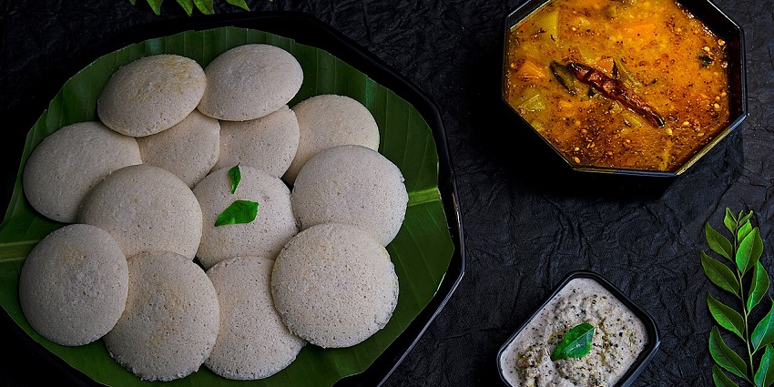 Steamed idlis and drumstick sambhar (onions and tomatoes), a staple dish of South India.
