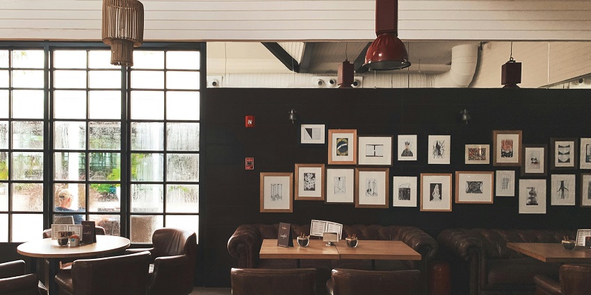 Cosy café with leather chairs, framed wall art, wooden tables and large window light in one of the cafes in Gangtok.
