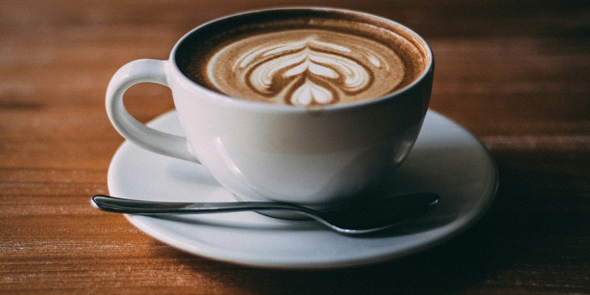 White ceramic cup of cappuccino with latte art served at The Coffee Shop.
