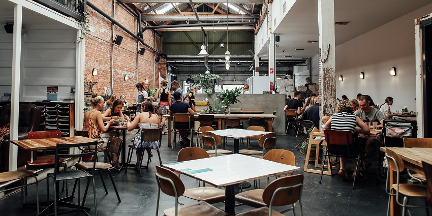 Crowded restaurant in a large space with brick walls, one of the famous Indian restaurants in Clarke Quay Singapore.
