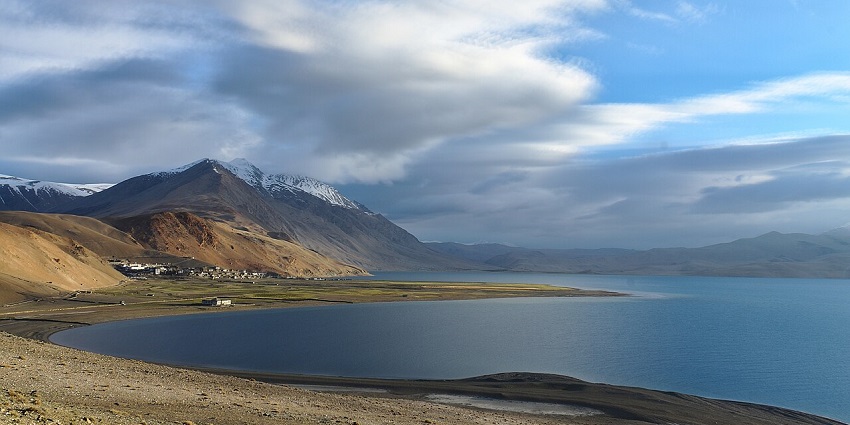 Scenic Tso Moriri lake with surrounding snow peaks and wild flora in national parks in Ladakh.
