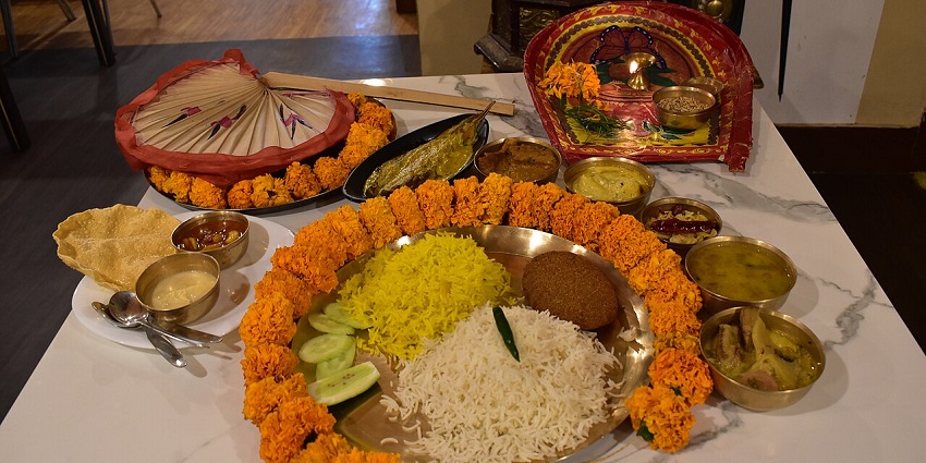 Veg thali platter filled with a variety of traditional Indian dishes like aloo bhaja and kofta.