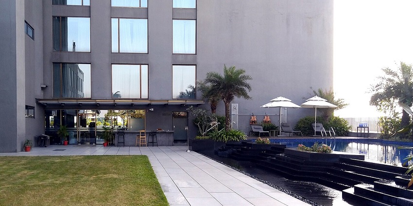 Modern hotel building with large glass windows, multiple floors, and a prominent façade.