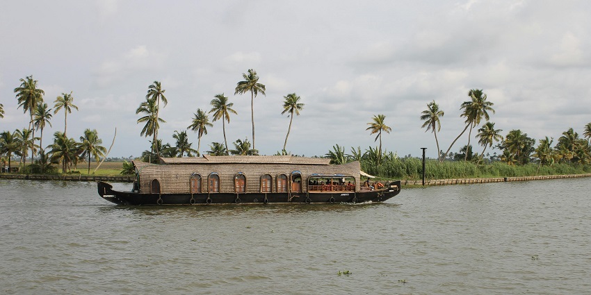 Boat floating on serene backwaters at Veli Tourist Village and Park in Kerala.
