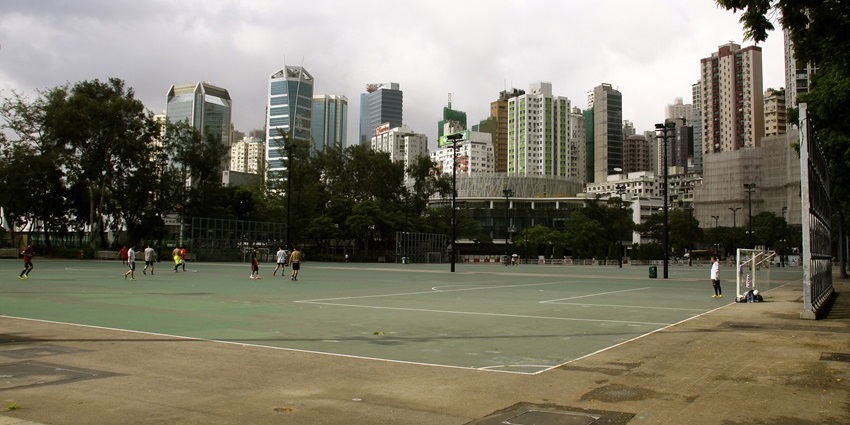People playing football on outdoor courts at Victoria Park, one of the best parks in Hong Kong.
