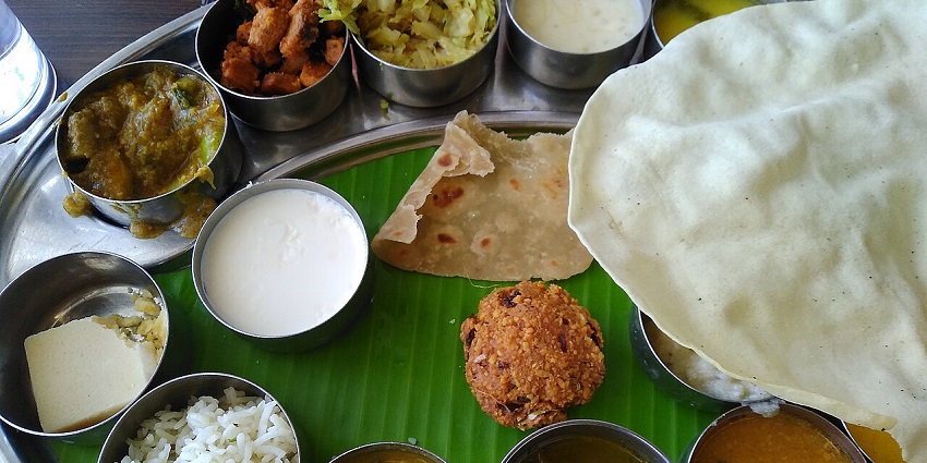 A South Indian veg thali with pooris, sambhar, rice, chutney and more local delicacies.