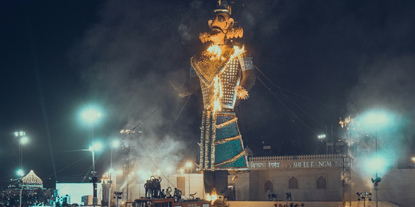 Tall effigies of Ravan set ablaze during a traditional Dussehra celebration event.