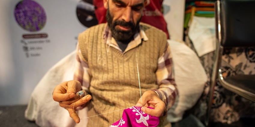 A man stitches a design on cloth at 44th India International Trade Fair, Pragati Maidan.