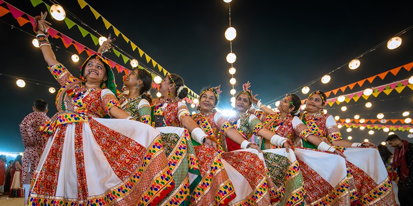 Group of women in colourful, embroidered chaniya cholis performing Garba during the best Navratri in India.