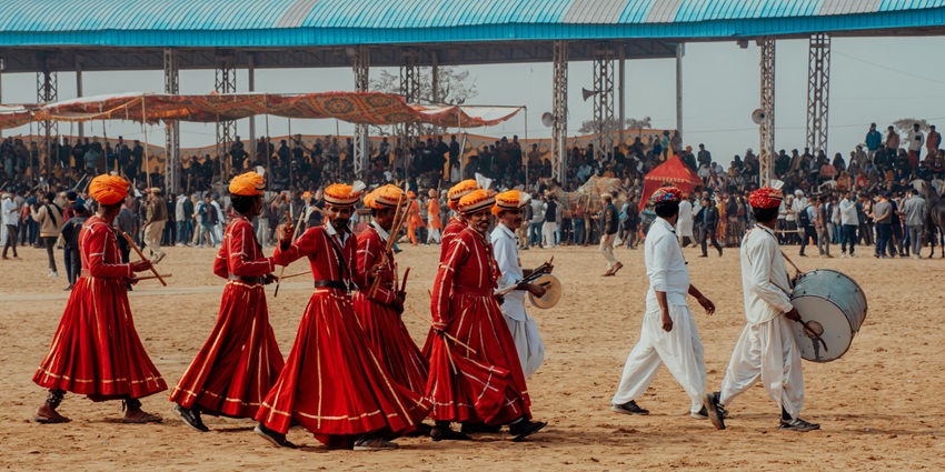 A group of people in traditional attire walking together at Pushkar Mela.