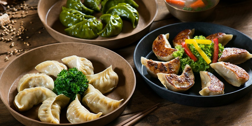 Three plates of assorted momos served fresh, enjoyed by visitors at the Cherry Blossom Festival Shillong.
