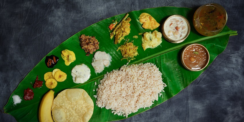 Traditional Onam Sadya feast with a variety of Kerala dishes served on a banana leaf.

