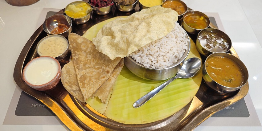 A colourful thali that is filled with a variety of curries, rice, chapati, and buttermilk in one of the pure veg restaurants in Siliguri.
