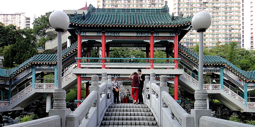 Exterior view of Wong Tai Sin Temple with grand stairs and traditional architecture.