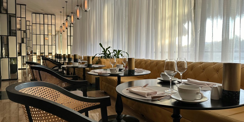 Elegant restaurant interior with golden seating, modern décor, and neatly set tables.

