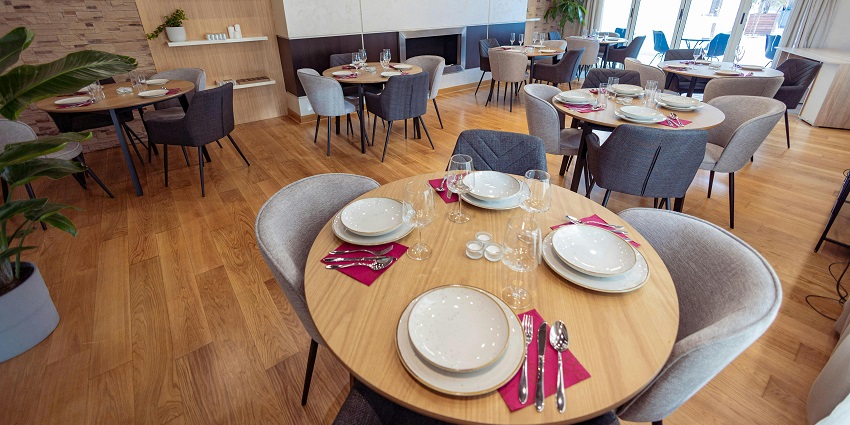 Stylish restaurant interior with soft lighting, neutral décor, and tableware arranged neatly, one of the best restaurants in Clarke Quay.
