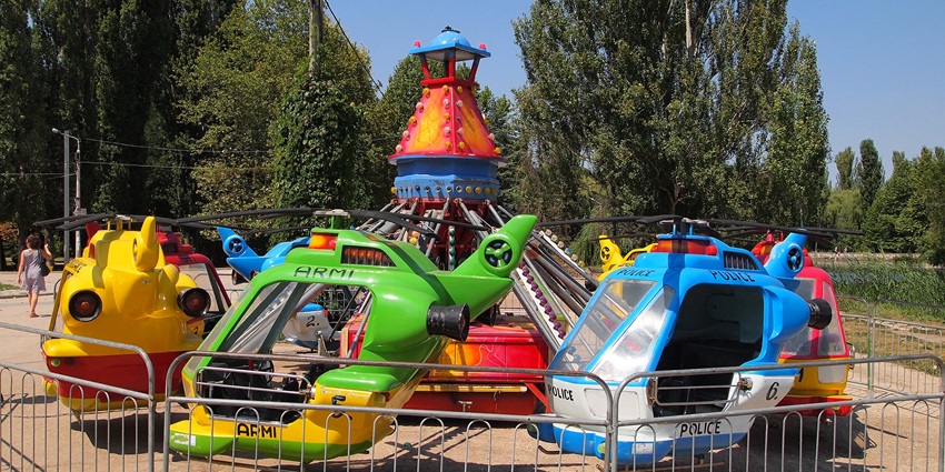 Image of colourful rides for kids in a park similar to the rides in Vautha Fair