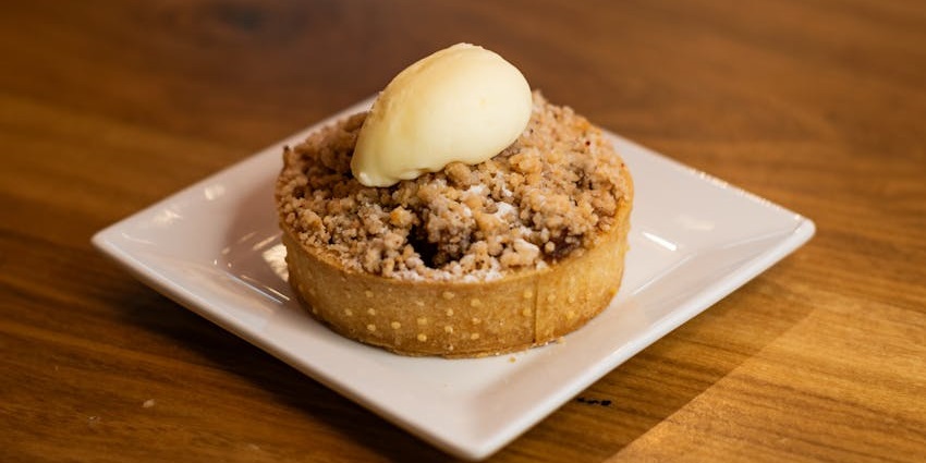 A small, golden-brown apple crumble tart with ice cream served at Apple Orchard Restaurant, one of the best restaurants in Lachung.