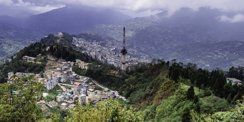 Aerial view of Gangtok city from Ganesh Tok showing hills, buildings, and misty green valleys