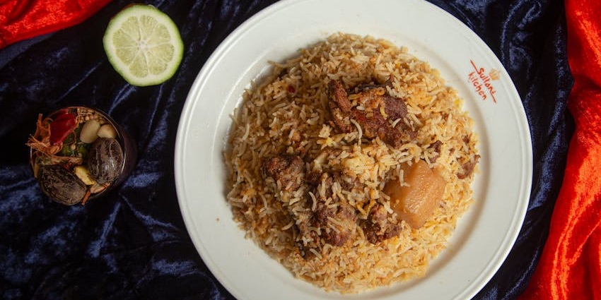 A large platter piled high with a generous serving of delicious, aromatic chicken biryani.