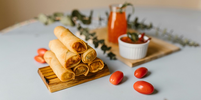 A plate of crispy spring rolls served with dipping sauce at Cafe Coffee Day.