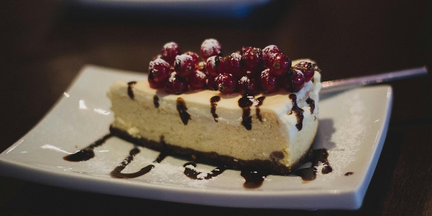 Slice of cheesecake served at Café Mocha on a white dessert plate.
